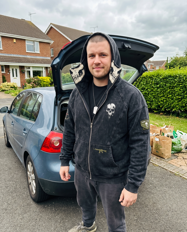 The Respawn Hoodie worn with the hood up in a driveway